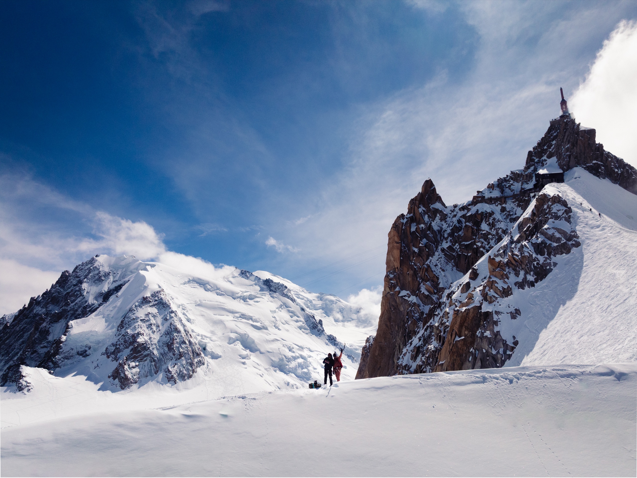 Aerial of the Mont Blanc massif above Chamonix, two ski-mountaineers crossing the snowfield